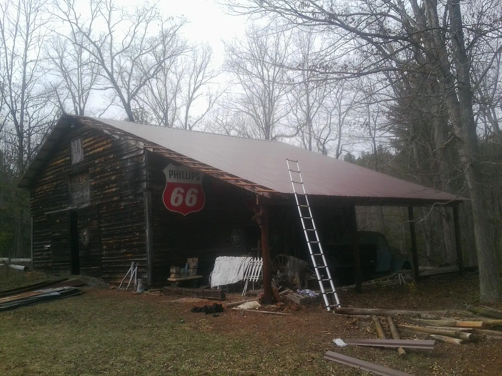 New metal roof on an open sided timber barn with a vintage sign in Bumpass
