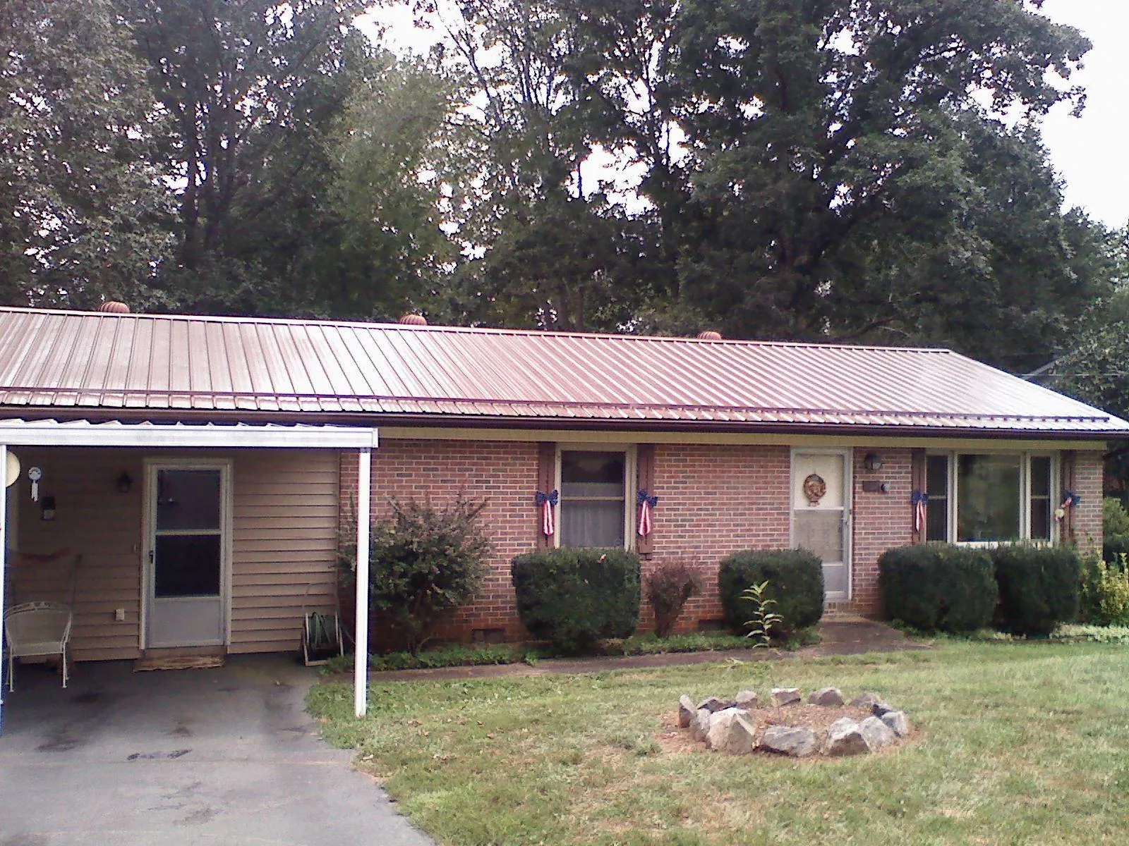 Bronze metal roof and carport on a brick ranch home — Roof Repair work by our crew in Bumpass
